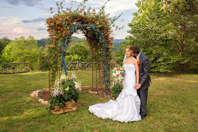 Bride and groom in front of an arbor